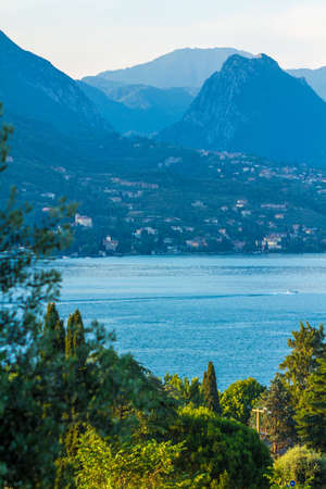 Lake Garda, Italy. peaceful sunset looking out over the lake from Maraschina toward the mountainsの写真素材