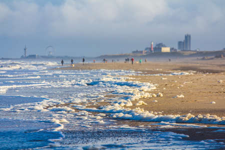 north sea storm blowing foam from sea onto Kijkduin beach, the Netherlandsのeditorial素材