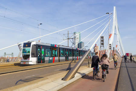 Rotterdam, the Netherlands - April 7 2018; people riding bikes over Rotterdam Erasmus bridge...