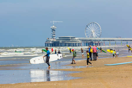 cheveningen, the Netherlands - June 27 2018: group of young people with surf boards on Scheveningen beach near pierのeditorial素材