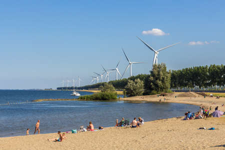 goeree overflakkee, the Netherlands - July 14 2018: summer day with people on dutch beach with...