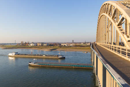 Nijmegen, the Netherlands - November 16 2018: cargo river barges passing under waal bridge in Nijmegen during time of low river levelsのeditorial素材