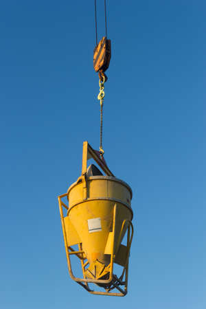 high crane concrete machine for spreading cement hoisted at building site on blue sky backgroundの写真素材