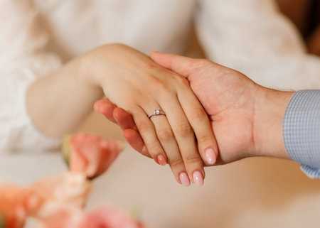 soft-focus close-up caucasian male holding woman hand diamond ringの写真素材