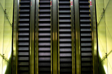 Escalator with sides lit up inside a shopping mall 