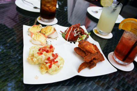 Business executives meeting over brunch discussion with serving of fried chicken wings, butter prawns and squids            の写真素材