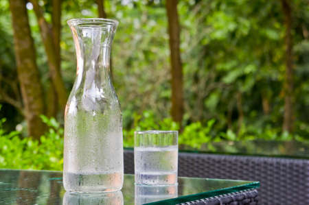 Clear Cold water flash and glass with greenery background. の写真素材
