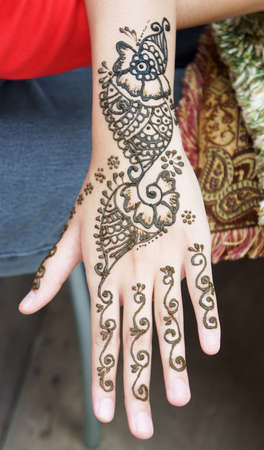Muslim Lady hand being decorated with henna tattoo               の写真素材