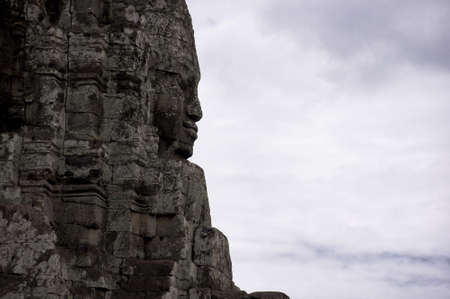 Sihouette of stone statue against sky at bayon の写真素材