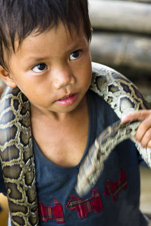 CAMBODIA â€“ May 2012: Young Snake performer at Tonle Sap Lake in Cambodia in May 2012.  Living...