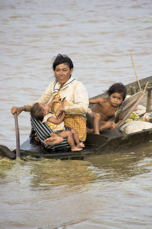 CAMBODIA â May 2012: Cambodian family in a rough wooden boat sailing in Tonle Sap Lake in Cambodia in May 2012.  Living conditions in the area are difficult - Cambodia
のeditorial素材