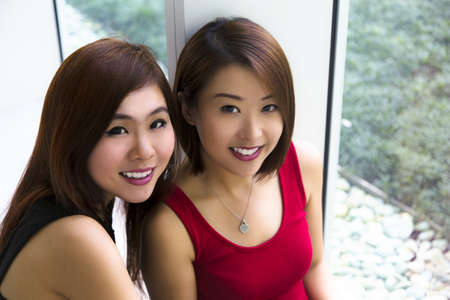 Close up of two charming Asian young ladies smiling の写真素材