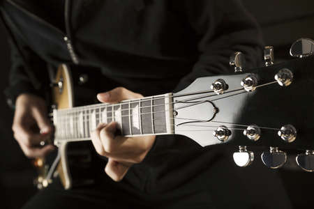 Close up of a boy playing a guitar. の写真素材