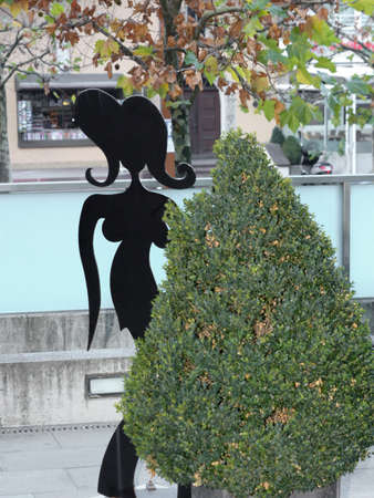 The silhouette of a female mannequin behind the bushの写真素材