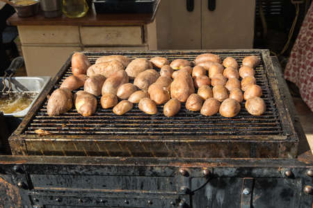 Fresh potatoes in their skins roasted on coals.の写真素材