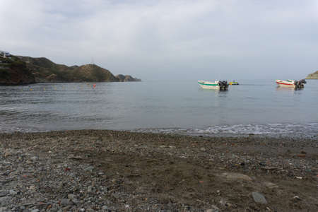 Motorboat in the sea seen from the coast with the sea and mountains in the distanceの写真素材