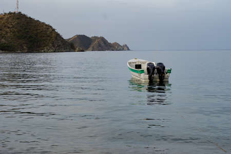 Single boat with green line in the middle of the sea with reflectionの写真素材
