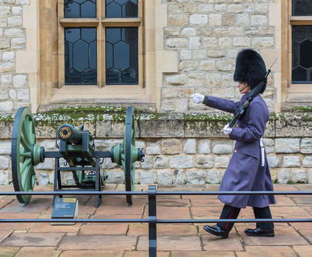 LONDON, UNITED KINGDOM - NOVEMBER 24, 2018: Royal Guard at Tower of London. Young soldier marches near a gunのeditorial素材