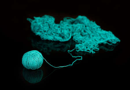 Pile of tangled yarn with a ball on the end leading out.の写真素材