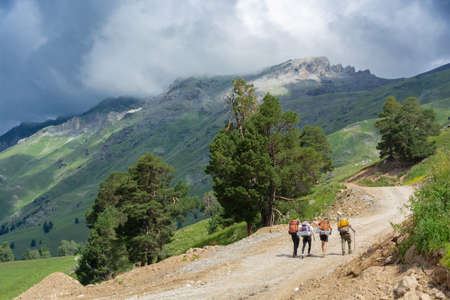 Four tourists travelers walking on the mountains to the passの写真素材