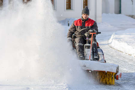 ISTRA, RUSSIA - FEBRUARY 05, 2021: Man with sweeping machine removing snowのeditorial素材