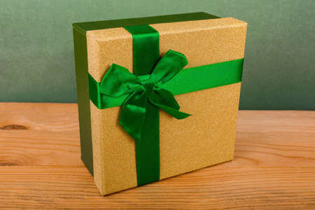 green box for christmas gifts on green background, christmas gifts, green ribbon, green bowの写真素材