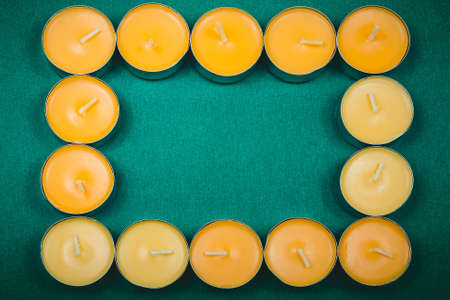frame on a green background of orange round candleの写真素材