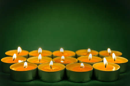 round orange burning candle on a green background, Christmas backgroundの写真素材