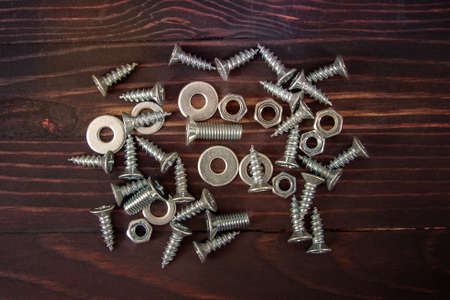 bolts, nuts and screws on wooden backgroundの写真素材