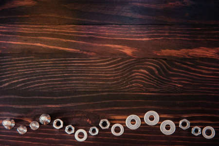 washers, nuts and bolts on wooden table.の写真素材