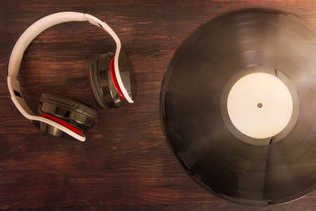 vinyl record and headphones on wooden background