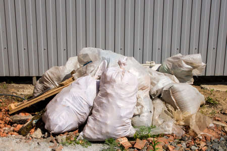 Bags of construction waste lying in a pile in the yardの写真素材
