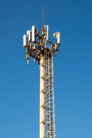 Cell tower against the blue sky. Tower with stairs.