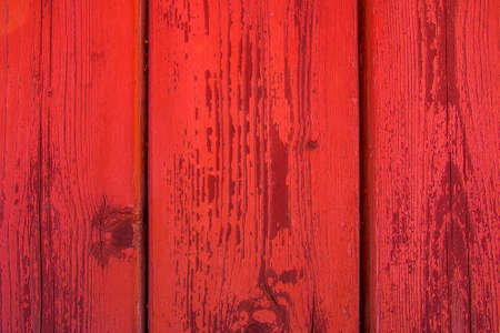 Old boards are red. Grunge background of red boards. Peeling red paint on the boards