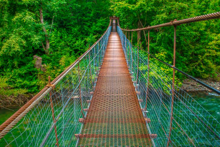 Suspended iron bridge across the riverの写真素材