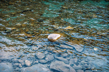 Dry stone sticking out of the waterの写真素材