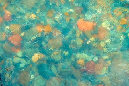 River stones in turquoise water. Water flows over the stonesの写真素材
