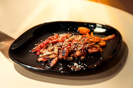 Japanese food on a black plate.