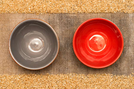 Frame made of burlap, rice grains. Two empty bowls, top view.の写真素材