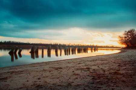 View from the Bank to the river in the evening. Concrete pillars in the waterの写真素材
