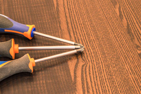 Three screwdrivers on the brown table