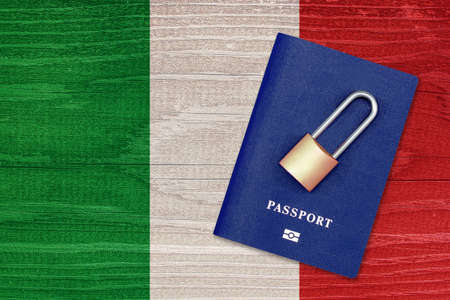 Passport and padlock on the background of the flag of Italy. Ban on leaving the country. Travel abroad is closed. Italian flag and passport. Ban on entering the countryの写真素材