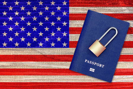 Passport and padlock on background of the flag of the United States. Ban on leaving the country. Travel abroad is closed. US flag and passport. Ban on entering the countryの写真素材