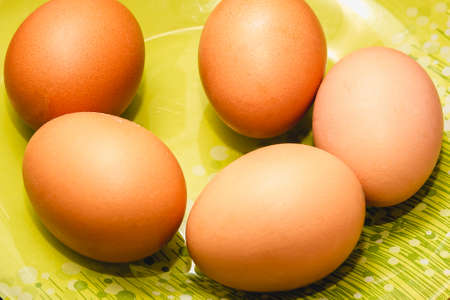 Boiled chicken eggs on a green platter, close-up