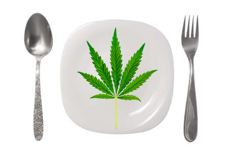 A white plate with a hemp leaf on it. An empty plate with a spoon and fork on a white background. Isolated Imageの写真素材