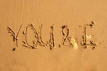 The inscription on the sand is you and me. It says you and me in the sandの写真素材