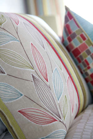 Closeup of floral and colorful pillows on bed in bedroomの写真素材