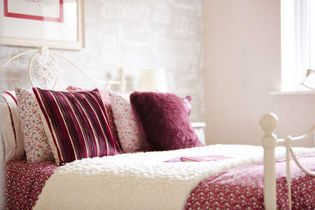 Shot of colorful pillows and bedding on a bed in luxurious bedroomの写真素材