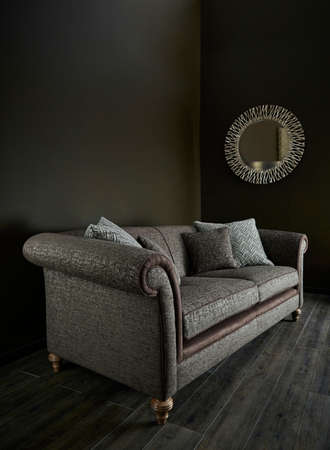 Shot of grey color armchair with pillow on hardwood floorの写真素材