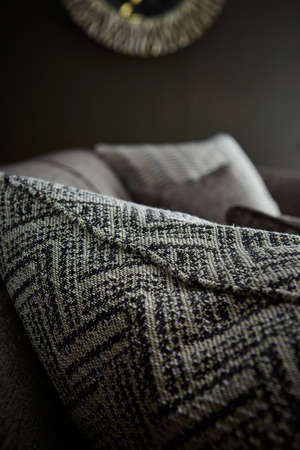 Shot of grey color armchair with pillow on hardwood floorの写真素材